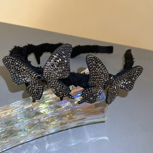 Macro view of crystal butterfly headband with black fabric and rhinestone details
