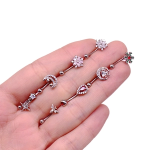 Close-up of stainless steel piercing rings featuring bee, snowflake, and star moon designs