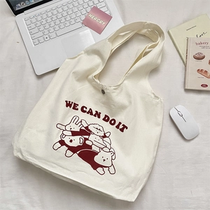 Détail d'un sac cabas en toile crème avec bouton pression et imprimé ours mignon