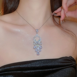 Gros plan du collier en argent avec des zircons en goutte sur le cou d'un mannequin