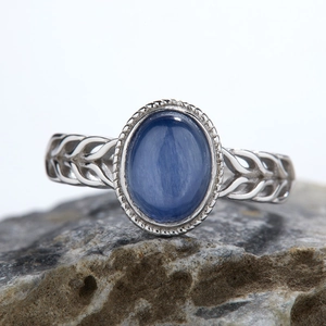 Macro shot of S925 sterling silver ring with oval blue gemstone and braided band design