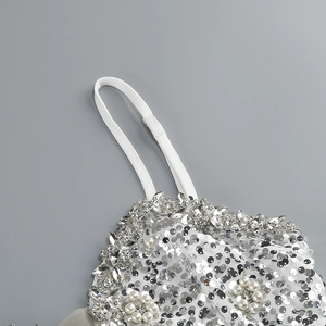 Dettagli di paillettes argento e perle cucite a mano su un mini abito con scollo a V