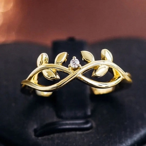 Anillo de hojas de vid doradas con circonita central en estilo minimalista natural