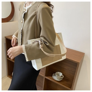 Detail of white beige tote bag with silk scarf handle in a cozy lifestyle setting