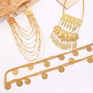 Detail von Vintage-Goldschmuck mit gravierten Münzanhängern und ethnischer Halskette