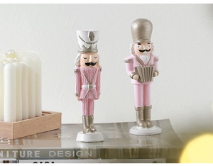 Pink and gold Nutcracker soldier ornaments with accordion on decorative books