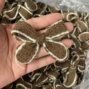 Handmade brown knitted yarn bow with white trim for DIY clothing and sweater accessories