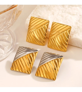 Macro shot of rectangular gold and bicolor earrings with diagonal striped textures