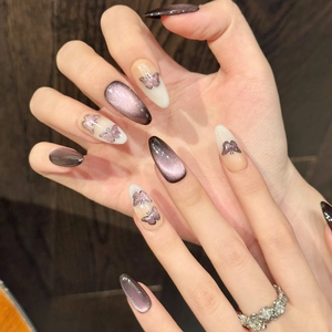Detailed view of dark purple cat-eye press-on nails with glitter butterfly art designs