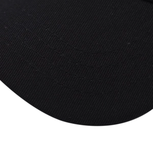 Detailed macro view of black twill baseball cap brim with parallel stitching and texture