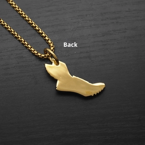 Vue arrière détaillée du pendentif chaussure ailée dorée sur une chaîne à maillons