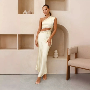 Détail de robe longue en satin jaune pâle avec épaule dénudée et bordure en dentelle