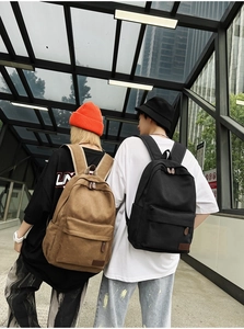 Canvas backpack in khaki and black colors shown on models in an urban street setting