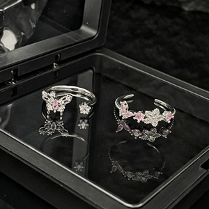 Detail of silver butterfly and floral rings with pink crystals in a black display box