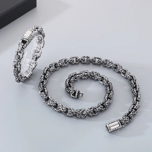 Detail of vintage hammered steel bracelet and necklace set with a retro oxidized finish