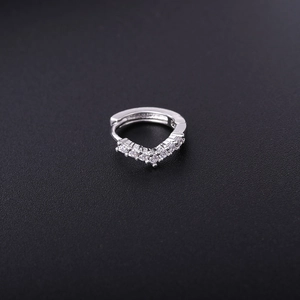 Close-up of a silver V-shaped huggie earring set with seven sparkling zircon stones
