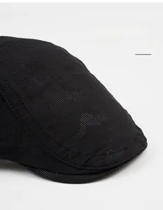 Detail of black newsboy cap featuring breathable mesh texture and wide brim for sun protection