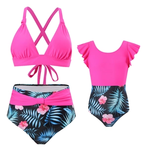 Vue à plat d'un ensemble de maillots de bain mère-fille rose avec imprimés tropicaux