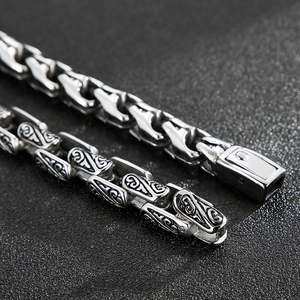Macro detail of vintage engraved links on a retro titanium steel men's chain bracelet
