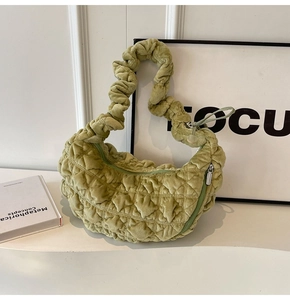 Close-up of pistachio green velvet bag showing quilted texture and ruched strap detail
