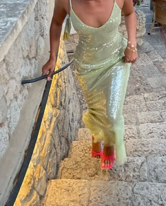 Detailed view of mint green sequin maxi dress featuring thin straps and deep V-neckline