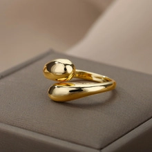 Macro shot of gold teardrop open ring on dark velvet box with elegant glossy finish