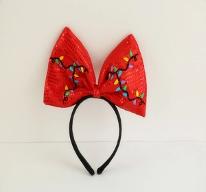 Detail of red sequin bow headband with Christmas light patterns on a black band
