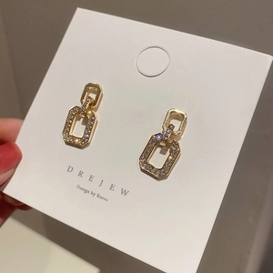 Detailed view of gold geometric square drop earrings with sparkling pavé crystal accents