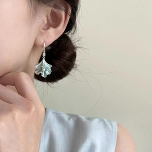 Elegant ginkgo leaf dangle earrings with sparkling cubic zirconia on a female model