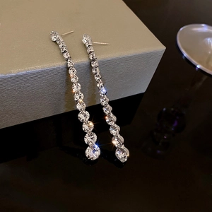 Macro view of long silver tassel earrings with sparkling round cubic zirconia stones