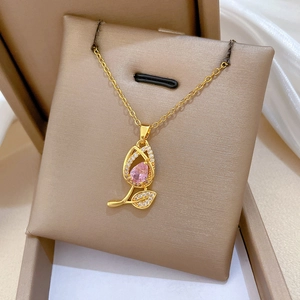 Elegant gold tulip necklace featuring pink drop stone and zircon on a jewelry box