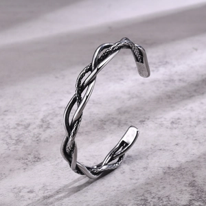 Close-up of vintage silver cuff bracelet with braided texture and aged finish