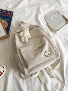 Minimalist off-white high capacity nylon backpack with plush bear and rabbit pin