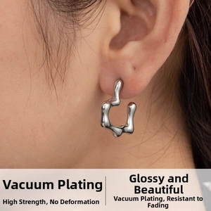 Close-up of a silver liquid metal wave earring with irregular geometric texture