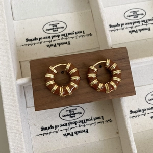 Gros plan de boucles d'oreilles créoles cœur arc-en-ciel sur bois de noyer
