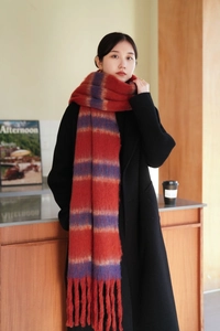Detail of thick knit scarf texture with handmade tassels and color block stripes
