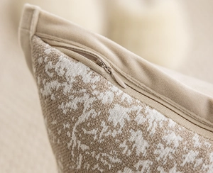 Macro shot of beige textured fabric pillow cover showing the hidden zipper detail