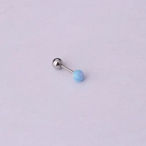 Macro shot of stainless steel cartilage earring with a blue opal stone and screw back ball