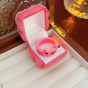 Close-up of pink cartoon animal ring with a shell-shaped velvet jewelry box