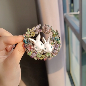Vintage rabbit brooch with colorful rhinestones and gold floral wreath on a coat