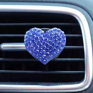 Close-up of heart-shaped car air vent clip with sparkling blue rhinestones decor