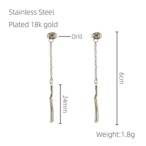 Détail macro de boucles d'oreilles pompons 6cm en acier inoxydable plaqué or 18 carats