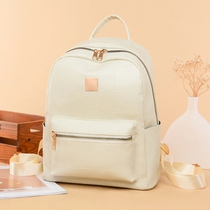 Detail of minimalist cream faux leather backpack with metallic zipper and textured stitching