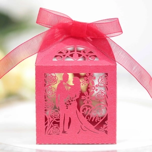 Red laser-cut wedding favor box with groom and bride silhouette and ribbon bow
