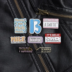 Close-up of enamel pins featuring SWIFTIE and The Eras Tour lyrics on black leather jacket