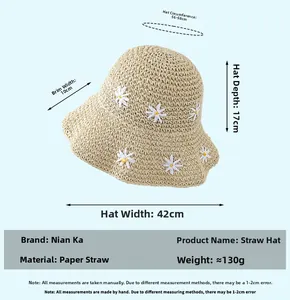 Close-up of lightweight straw hat with white daisy appliqués and 10cm wide sun brim