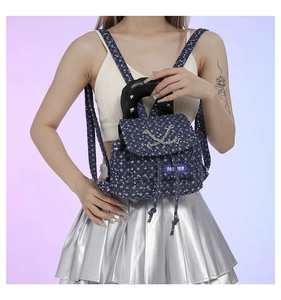 Close-up of mini denim floral backpack with metallic chain and fashion label detail