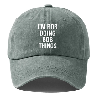 Washed cotton vintage baseball cap in dark grey with I'M BOB DOING BOB THINGS text