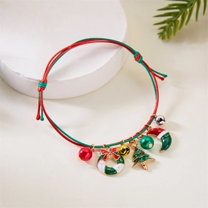 Detail of hand-woven Christmas bracelet with wreath and tree charms on a festive display