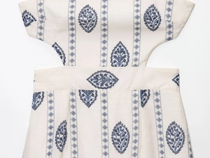 Detailed macro view of white embroidery and hollow-out design on the cotton linen dress